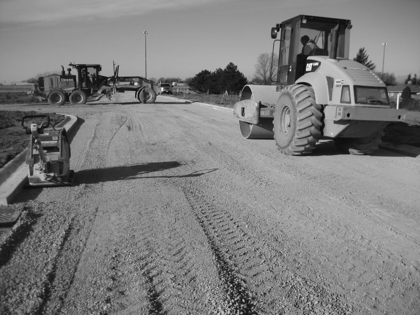 A black and white photo of tractors on the road.